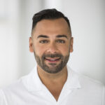 Edgar Villanueva smiles in his headshot. He's wearing a white shirt and is in front of a white, blurred background.